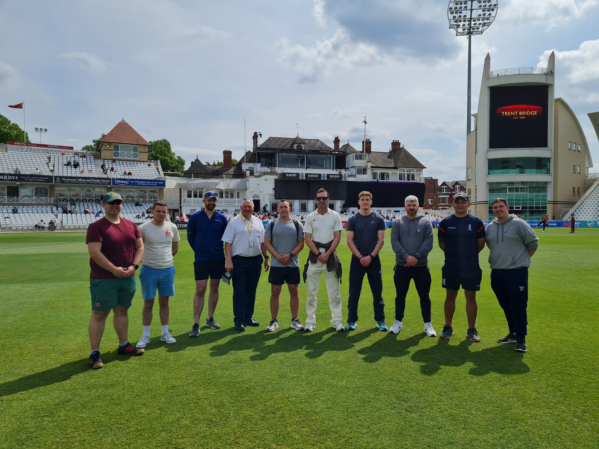 Group standing on the Trent Bridge cricket outfield during a team experience day.