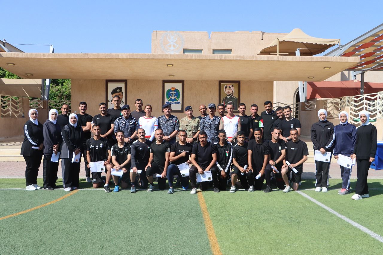 Group photograph of Royal Jordanian Navy trainees and instructors on a football pitch after a training course.